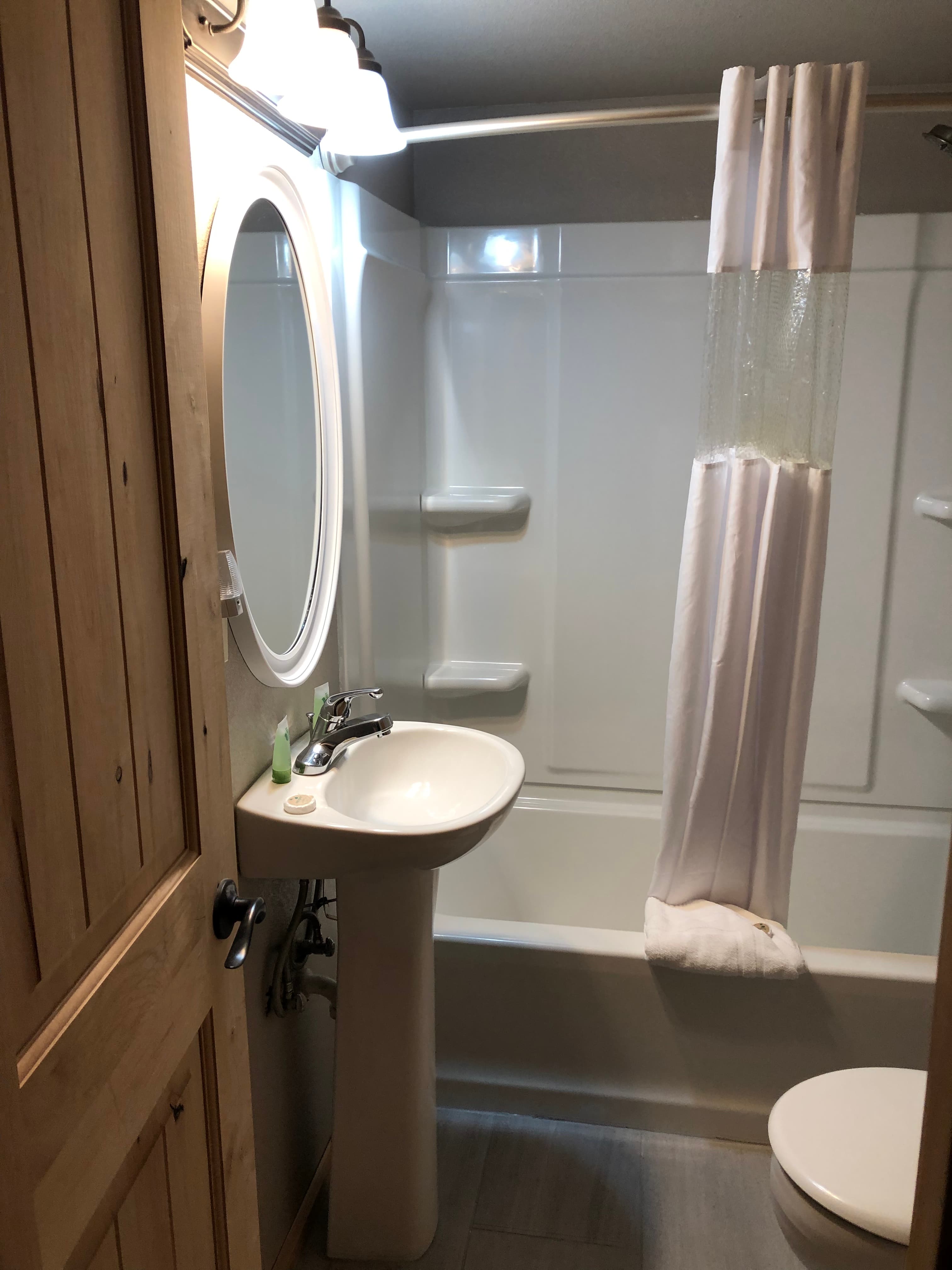 One bathroom with tub and shower combination, pedestal sink and large cabinet with bath linens, hair dryer and space for your personal tolietries.